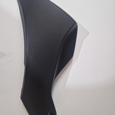 Peça de plástico preto com contornos curvos e orifício, sobre superfície branca.