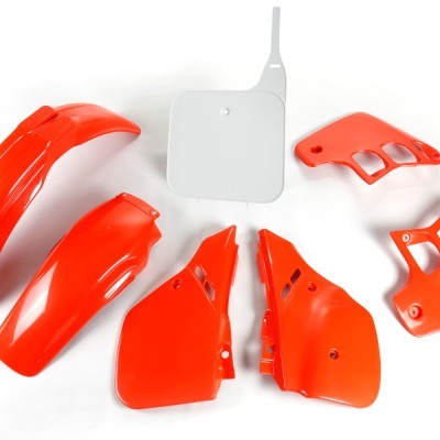 Carenagens vermelhas e uma peça branca em plástico sobre fundo branco