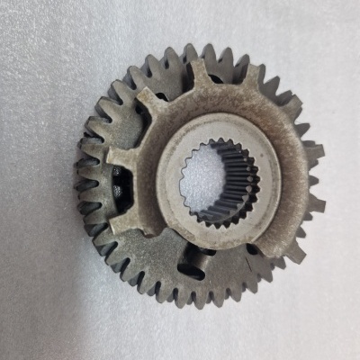 Engrenagem metálica cinzenta com dentes e abertura interna sobre superfície branca