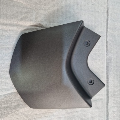 Peça plástica preta angular com dois orifícios, em tecido cinzento