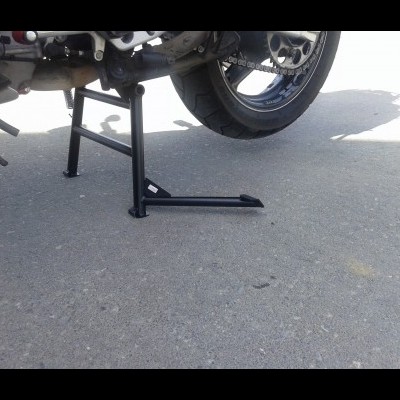 Suporte central montado em motocicleta em piso de asfalto