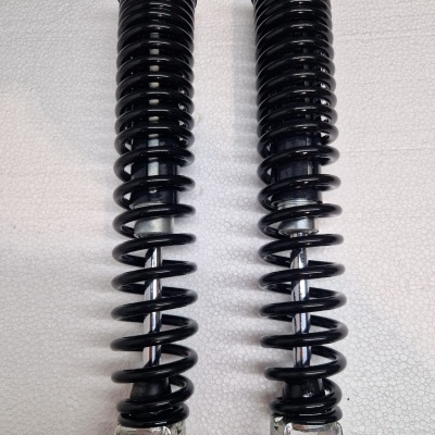 Par de molas amortecedoras pretas com acabamentos metálicos sobre fundo branco