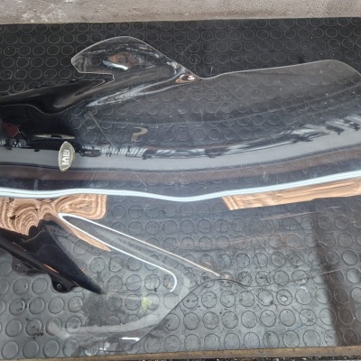 Para-brisas de moto transparente com suportes pretos em superfície de borracha preta