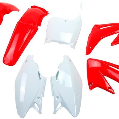 Peças plásticas vermelhas e brancas para mota sobre fundo branco