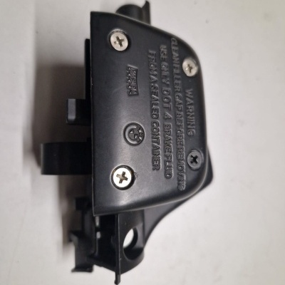 Peça preta com parafusos e texto gravado sobre fundo branco