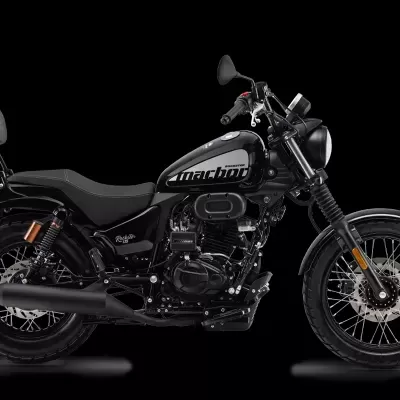 Motocicleta preta com texto 'machine' no depósito e fundo preto