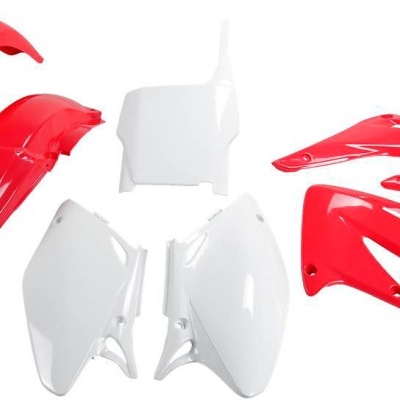 Peças plásticas de mota vermelhas e brancas numa superfície branca