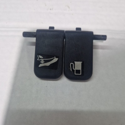 Duas tampas pretas de plástico com símbolos brancos, capot e combustível