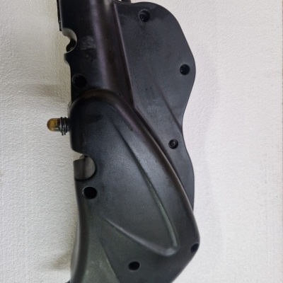 Peça automóvel preta de plástico com fixadores metálicos. 