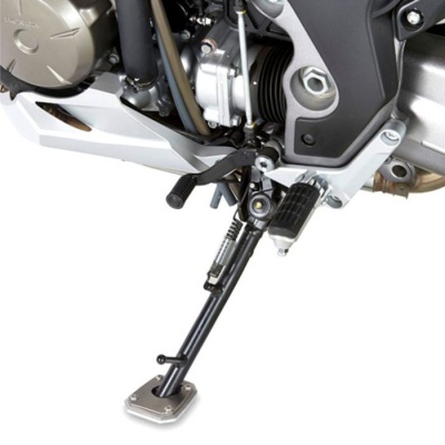 Suporte lateral metálico preto com base prateada de mota junto ao motor