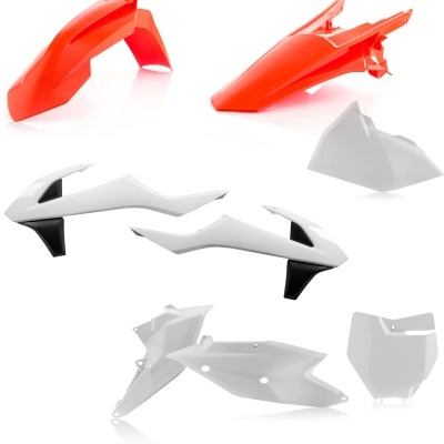 Peças plásticas para motocicleta em cores vermelha, branca e preta sobre fundo branco
