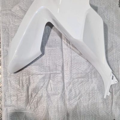 Carenagem plástica branca angular sobre tecido branco