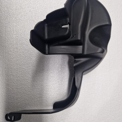 Peça plástica preta com formato irregular sobre fundo branco