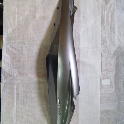 Peça lateral prateada e preta para mota com gravura XRX