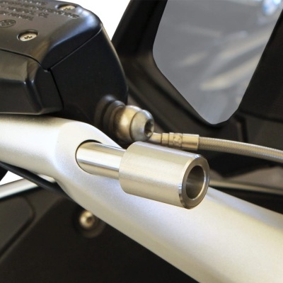 Componente metálico cilíndrico prateado ligado a estrutura preta e prateada com parafusos e tubo metálico