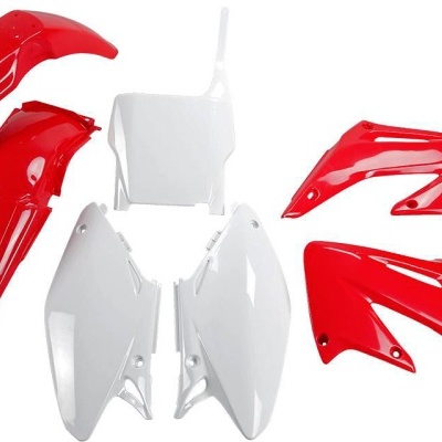 Peças plásticas vermelhas e brancas para mota em fundo branco