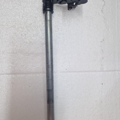 haste metálica com peça preta sobre superfície branca