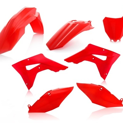 Peças plásticas vermelhas para mota sobre fundo branco