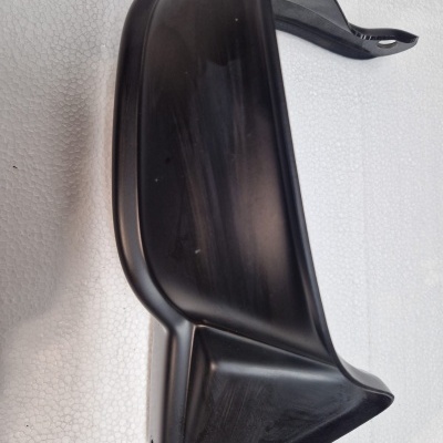 Peça plástica preta angular sobre fundo branco