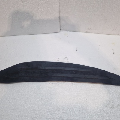 Tira longa curva em plástico preto sobre superfície branca texturada