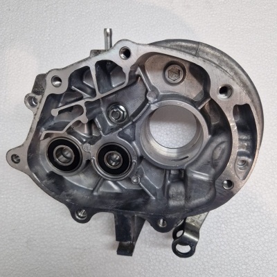 Carcaça metálica cinzenta de componente mecânico com orifícios e parafusos