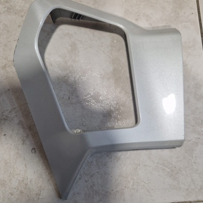 Peça plástica cinzenta com recorte retangular em pavimento de azulejos