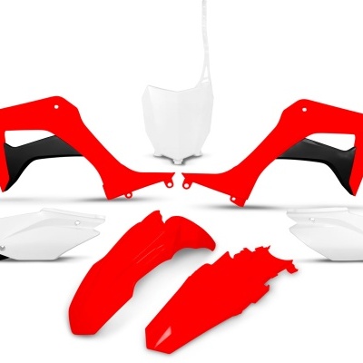 Peças plásticas de moto em vermelho, branco e preto sobre fundo branco