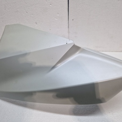 Banco de mota cinza claro em superfície branca.