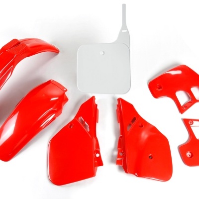 Peças plásticas de mota vermelhas e branca sobre fundo branco