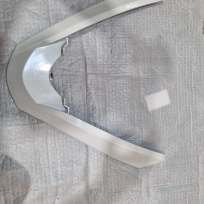 Peça plástica branca angular sobre tecido branco com textura