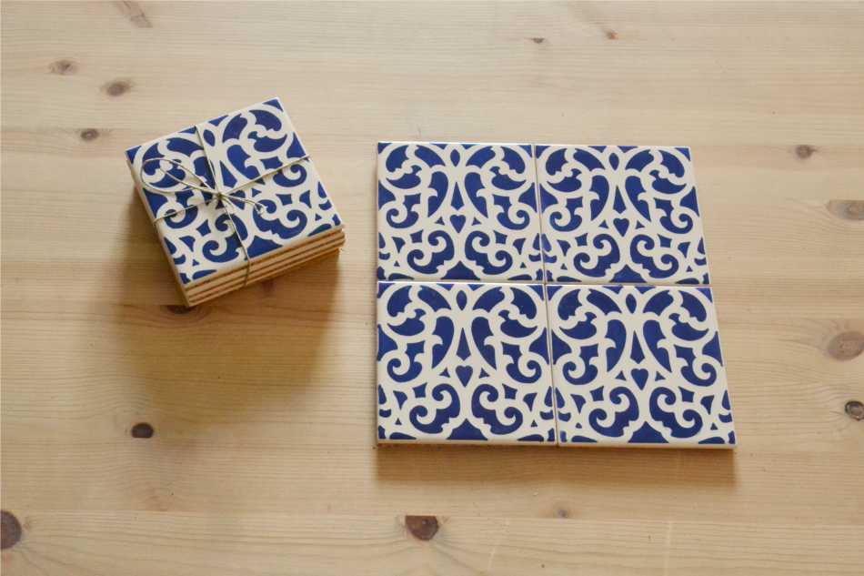 Coasters Set in portuguese tiles, hand painted, Set F Azulejos decorativos quadrados padrão azul e branco sobre madeira clara.