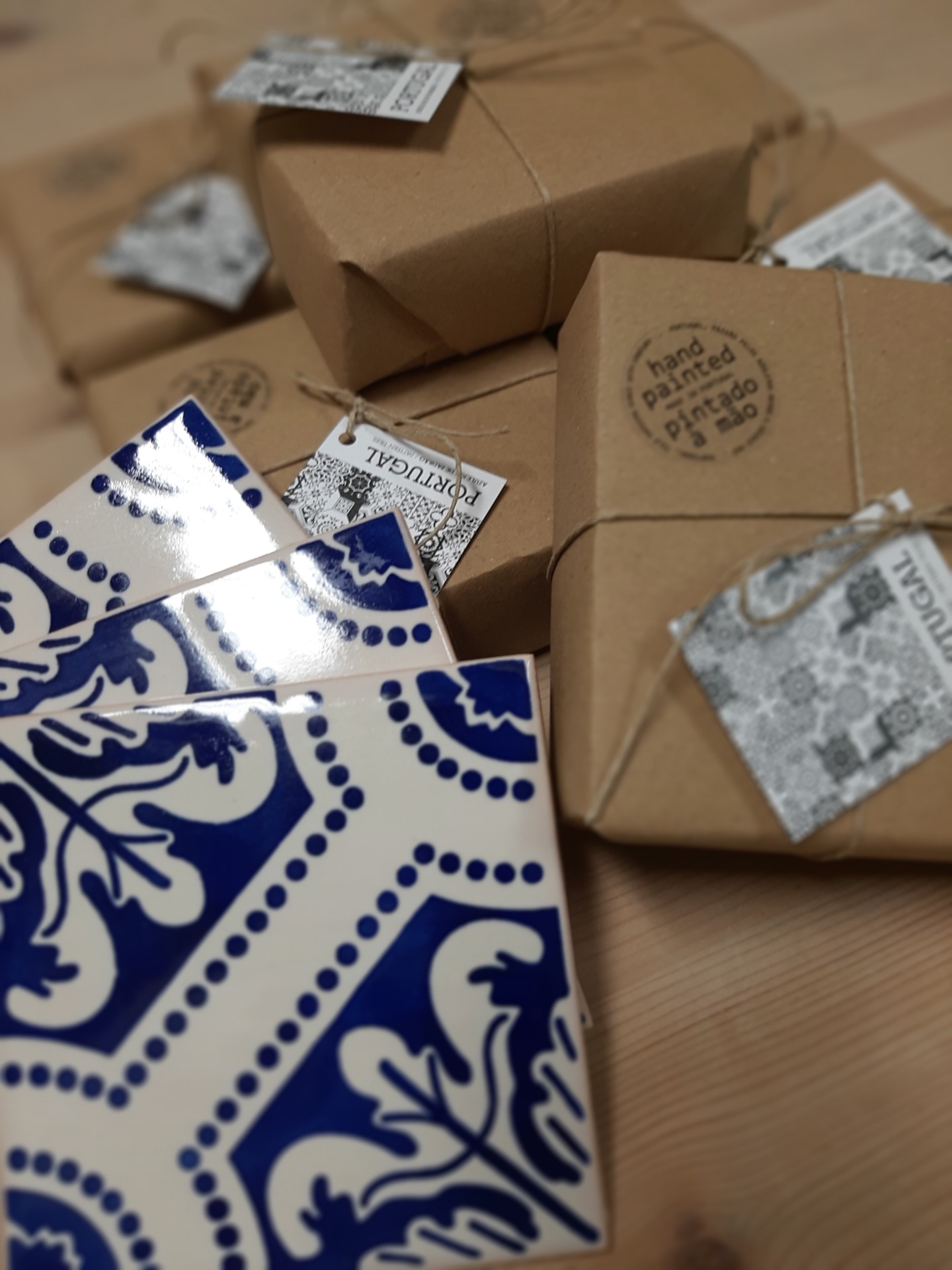 Blue and white ceramic tiles next to wrapped brown packages with tags and hand painted stamp