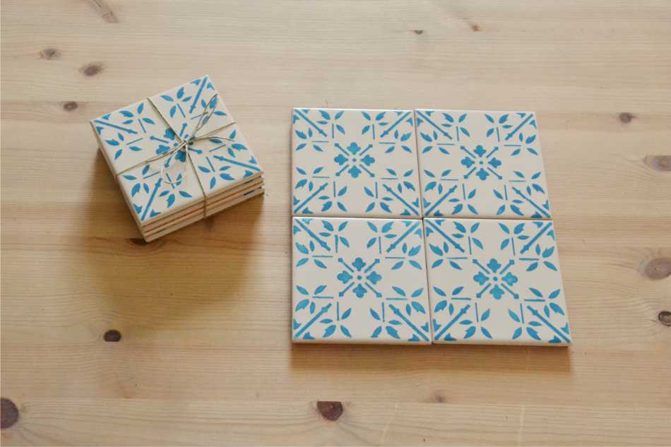 Coasters Set in portuguese tiles hand painted, turquoise, Set J Conjunto de azulejos cerâmicos brancos com padrão azul sobre mesa de madeira clara