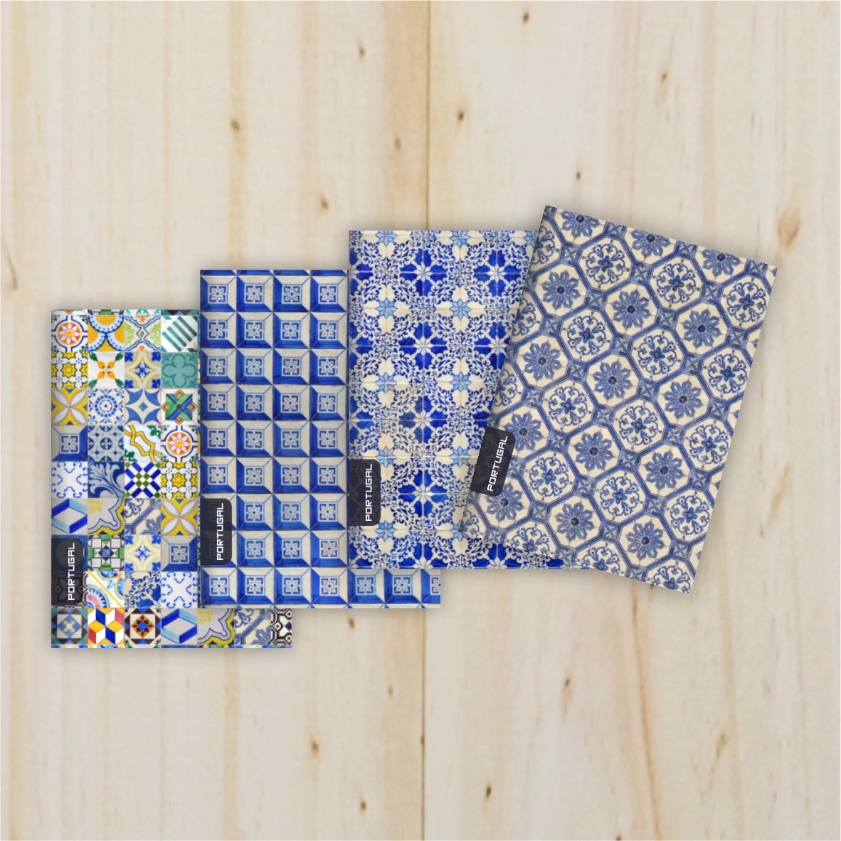 Set 4 Notebook Portuguese Tiles - Option B Conjunto de quatro panos de cozinha com padrões de azulejos portugueses em azul e branco sobre madeira clara.