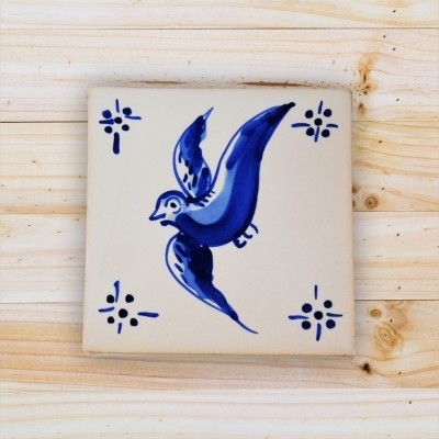Azulejo quadrado branco com pássaro azul e detalhes azuis nos cantos