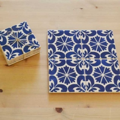 Azulejos cerâmicos azul e branco com padrão floral sobre mesa de madeira