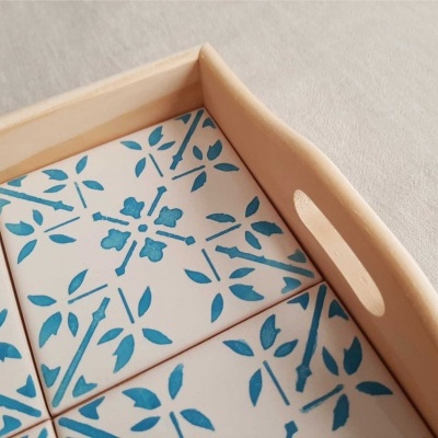 Tabuleiro de madeira com azulejos brancos e padrão azul floral