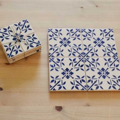 Conjunto de azulejos de cerâmica com padrão azul e branco sobre mesa de madeira clara