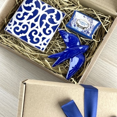 Gift box with ceramic tile, blue ceramic bird, and small box labeled PORTUS CALE