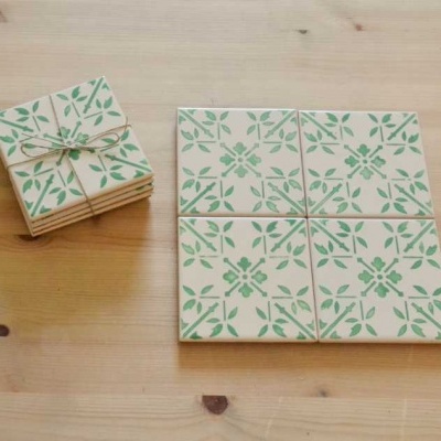 Azulejos quadrados de cerâmica com padrão verde floral sobre fundo bege