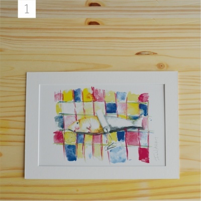 Moldura branca com pintura aquarela colorida de peixe sobre fundo quadriculado colocada em madeira clara