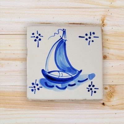 Azulejo de cerâmica branca com desenho azul de barco à vela