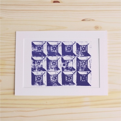 Quadro decorativo com impressão gráfica azul e branco sobre madeira clara.