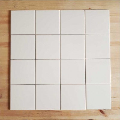 Conjunto de 16 azulejos brancos quadrados em matriz sobre madeira