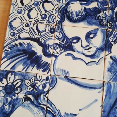 Azulejos cerâmicos azuis e brancos com imagem de anjo e padrões florais