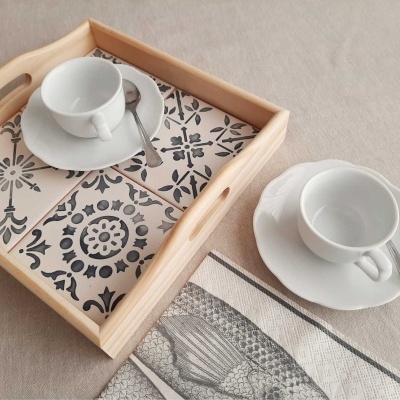 Bandeja de madeira com azulejos azuis e brancos, chávenas e pires brancos com colheres