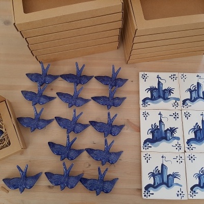 Figuras de pássaros azuis em cerâmica com azulejos decorativos azuis e caixas de cartão