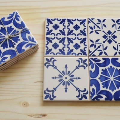 Azulejos cerâmicos azuis e brancos com padrões geométricos e florais sobre madeira clara