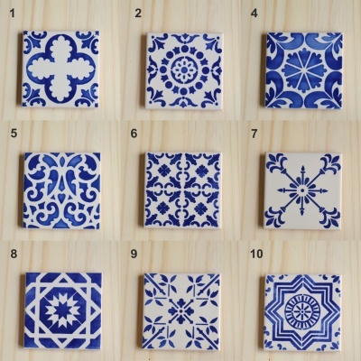 Dez azulejos quadrados com padrões azuis em fundo branco dispostos sobre madeira clara