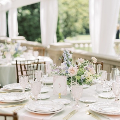 Mesa decorada para evento com flores, copos rosa e etiqueta número 5